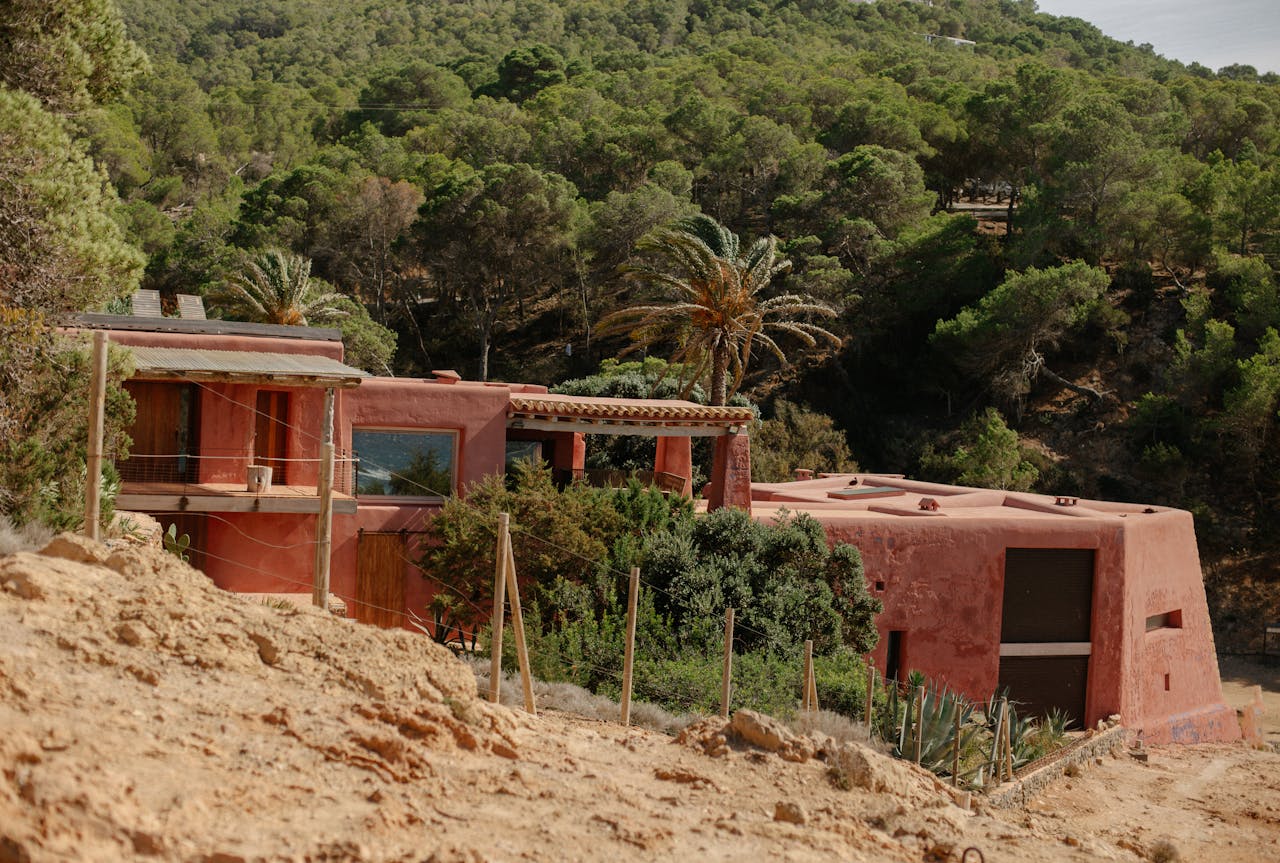 A charming rustic villa nestled in the lush hills of Ibiza, showcasing Mediterranean architecture.